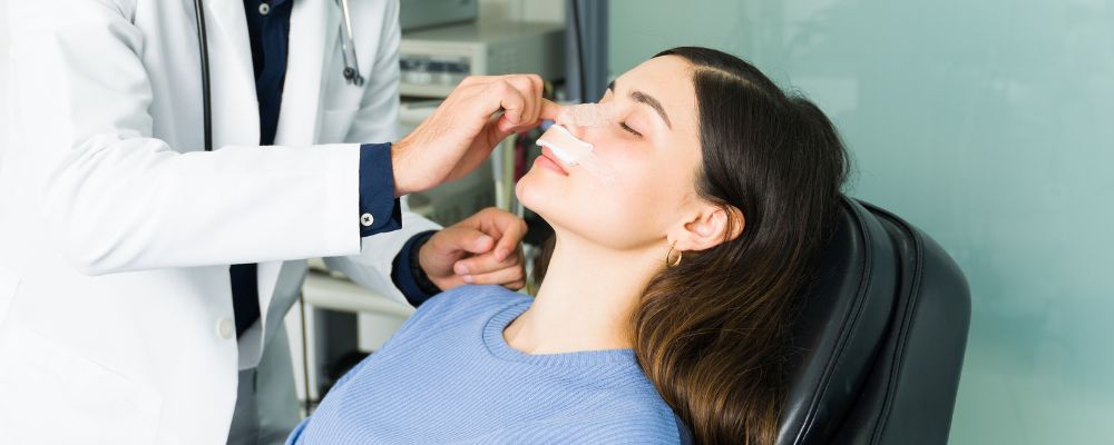 Mulher tendo seu nariz sendo avaliado por um otorrinolaringologista