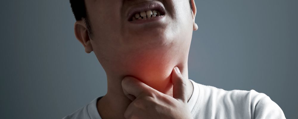 homem com dor na garganta causada pelo abscesso amigdaliano