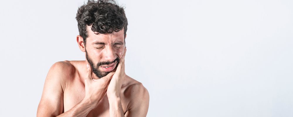 Homem com dor no ouvido causada pelo otite externa