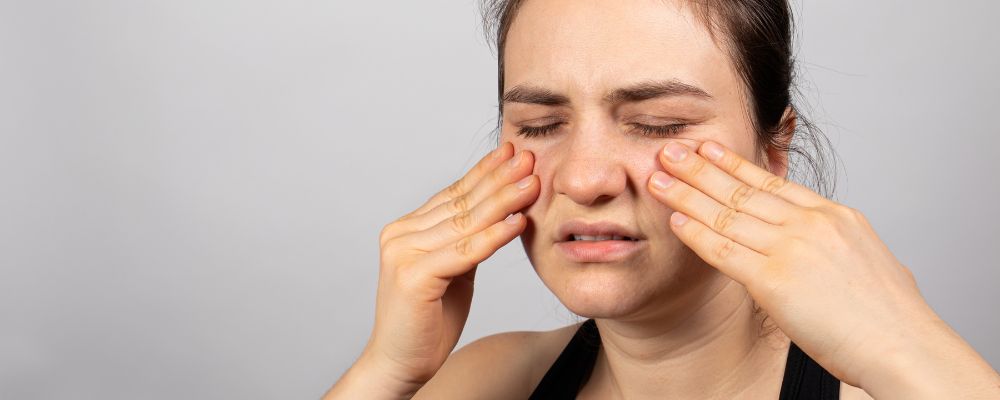 Mulher com dores no rosto causada pela rinossinusite